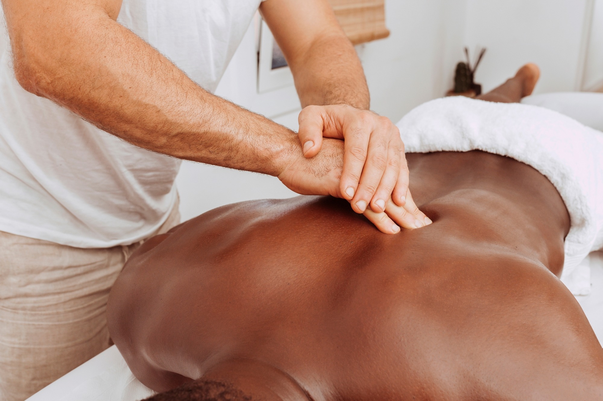 Close-up view of masseur hands giving treating massage to his patient.