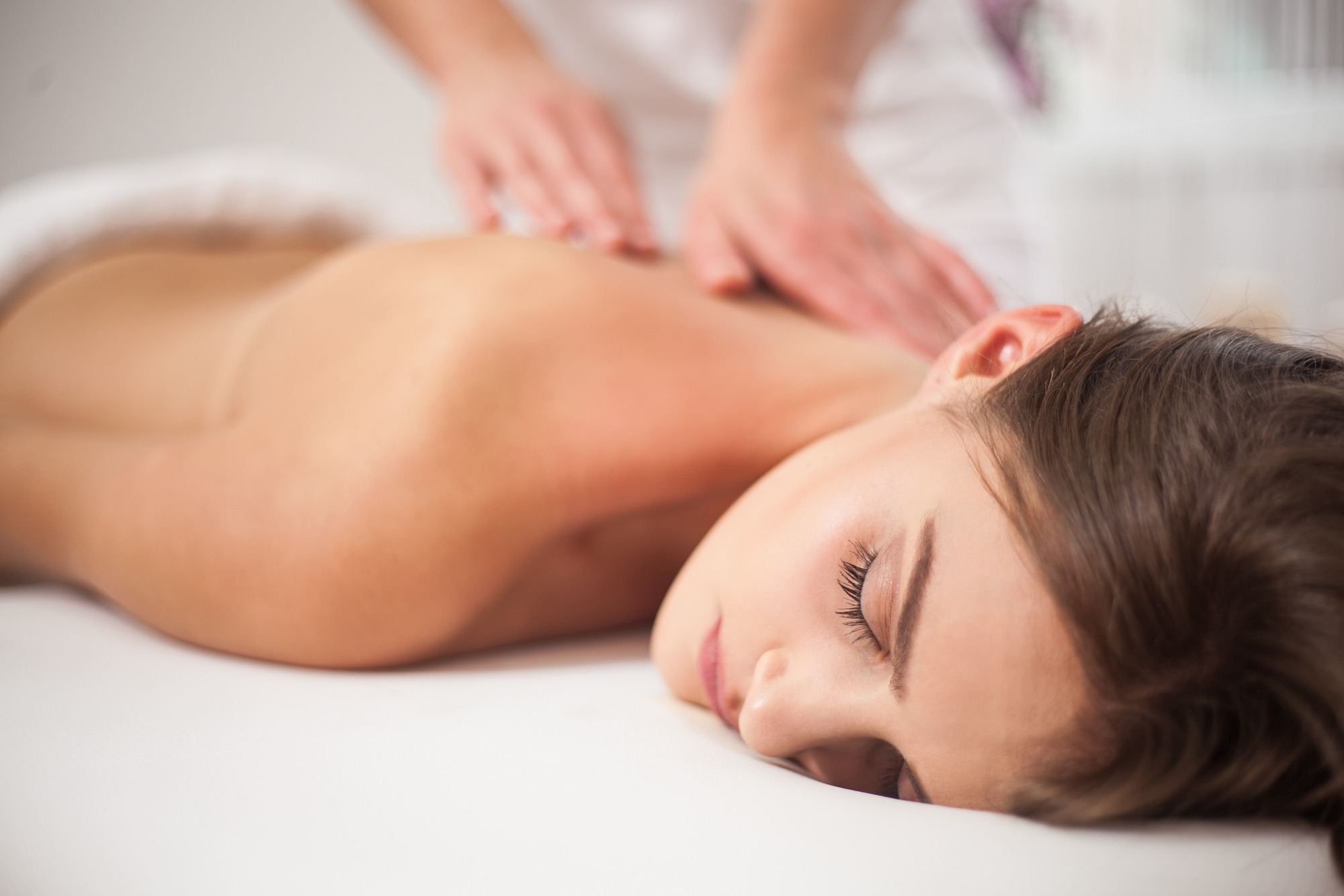 Young woman receiving back massage at spa